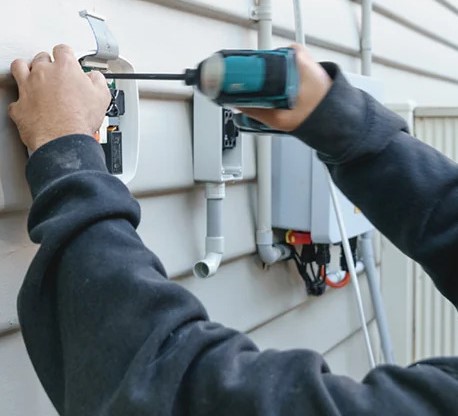 Technician fitting magnetic sensors to rolling shutter track
